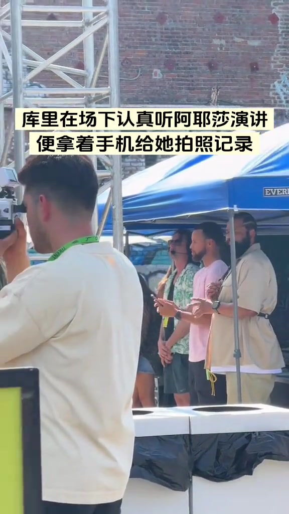 庫(kù)里在場(chǎng)下聽(tīng)阿耶莎演講一邊聽(tīng)一邊拍照記錄